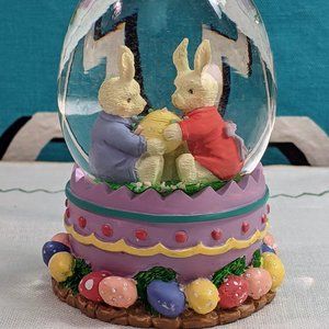Easter-themed vivid-colored egg-shaped snow globe Easter bunnies and Easter egg